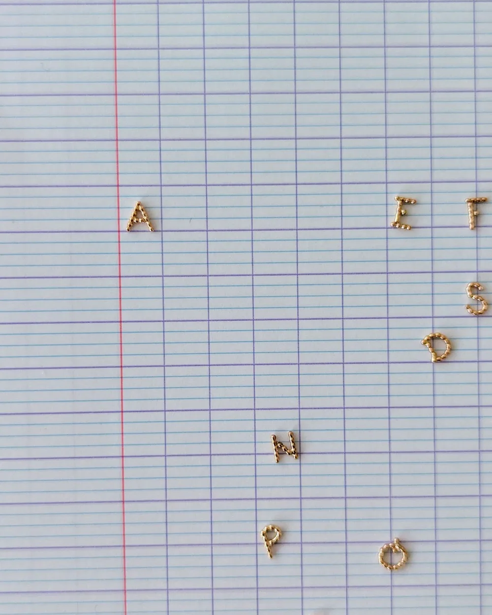 Lettres perlées disposées sur une feuille
